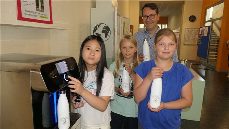 Im Beisein des stellvertretenden Schulleiters und Fördervereinsmitglieds Roland Pohl befüllen Yaoke Chen, Matthis Linde und Mona Waßweiler (v. l.) von der Schülergenossenschaft EGON die ersten Eichendorff-Trinkflaschen am neuen Wasserspender.  Foto: Hansjörg Schütz