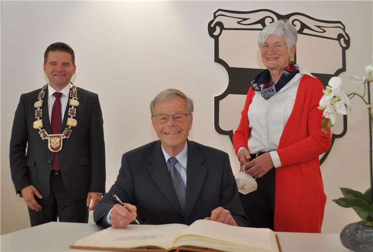 Im Beisein von Bürgermeister Holger Jung (links) und Wettes Ehefrau Annegret (rechts) trugt sich Walter Wette in das Goldene Buch der Stadt Meckenheim ein. Foto: Stadt Meckenheim