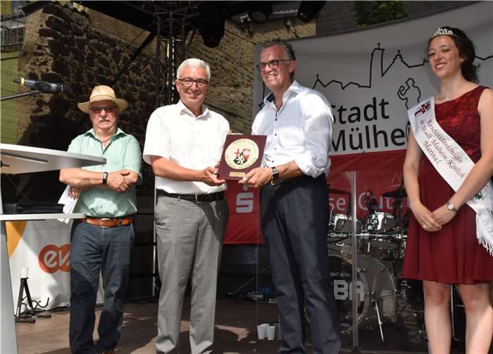 „Stadt ist ein Titel ohne Mittel“ Im Beisein von Moderator Winfried Erbar (v.li.) überreichte Roger Lewentz an Gerd Harner das Wappenschild.