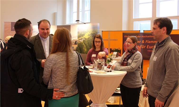 „Feuer und Flamme für Euch“ ist das Motto  Im Gespräch: Dechant Jörg Schuh mit einem interessierten Pärchen, das über die Hochzeitsmesse schlendert.