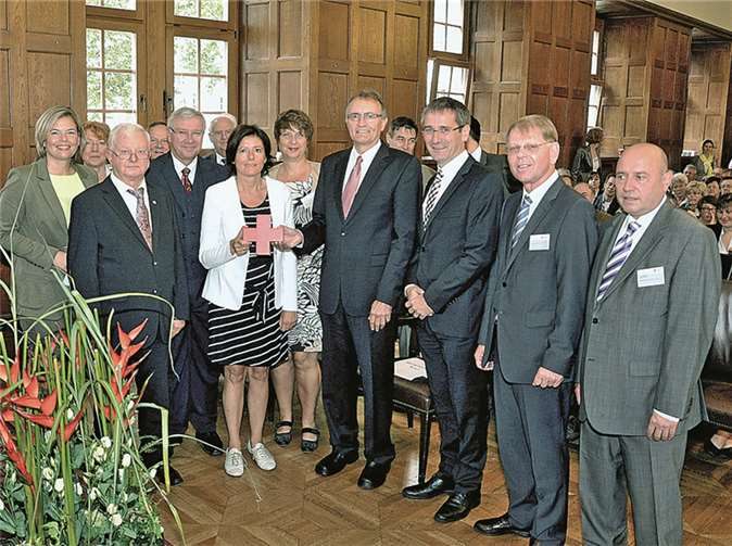 Im Kreis zahlreicher Gäste halten Ministerpräsidentin Malu Dreyer und Landrat Rainer Kaul das Rote Kreuz.uko