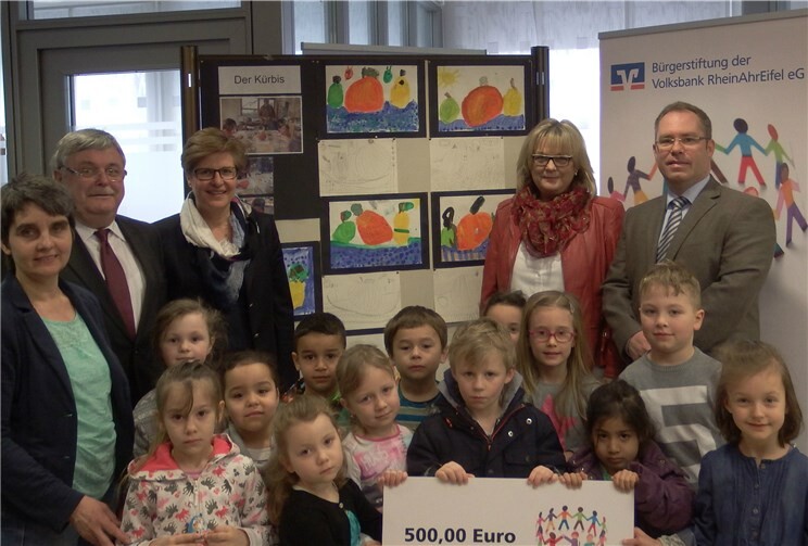 Im Namen der Bürgerstiftung der Volksbank RheinAhrEifel übergeben in Mendig Filialleiter Bernd Kill (2.v.r.)) und Privatkundenberaterin Kirsten Pflaum (3.v.l.) die Spende für neue Spielgeräte an die Kindergartenkinder, die Kindergartenleiterin Ulla Nürenberg (2.v.r.), Betreuerin Uschi Frank (1.v.l.) sowie den Vorsitzenden des Fördervereins Andreas Hammes (1.v.r.) privat