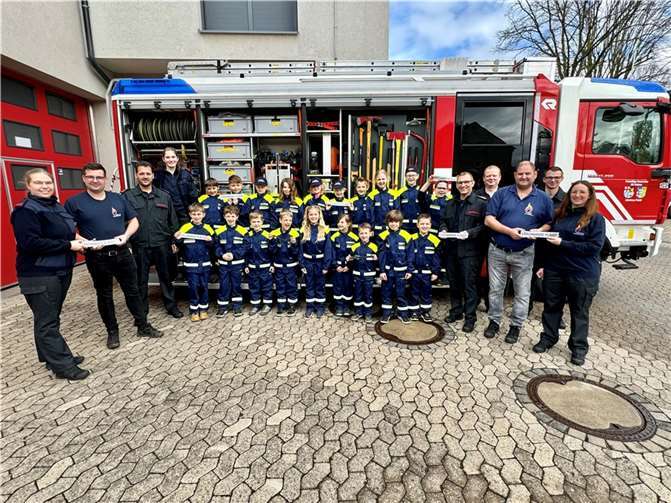 Im Rahmen einer Gruppenstunde konnten Leoni Buthe (links) und Annika Heuft (rechts) gemeinsam mit Jürgen Kaiser (3.v.r.), Lukas Bonn (2.v.l.), Björn Reichard (4.v.r.), sowie Dirk (5.v.r.) und Kai Schwindenhammer (3.v.l.) die Uniformen den Kindern übergeben. Foto: Feuerwehr Plaidt/ Leoni Buthe