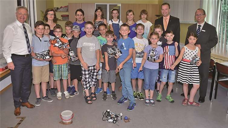 Im Trainingslager für Robonauten präsentierten die kleinen Nachwuchstechniker den Sponsoren von Volksbank und Kreissparkasse, Elmar Schmitz (l.) und Christoph Weitzel (2.v.r.), stolz ihre selbst gebauten und programmierten Roboter. privat