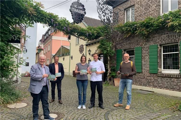 Im Weinhaus zur Traube präsentierten die Betreiber Kathrin und Florian Lanz (Mitte) gemeinsam mit Stadtbürgermeister Gerhard Hausen, dem Geschäftsführer der Tourismus Siebengebirge GmbH Oliver Bremm und Thomas Herschbach (Leitung Stabsstelle Kulturstadt-Büro) die Flanier-Broschüre „Siebengebirge – Vorschläge zum Zielgerichteten Gehen“ der Tourismus Siebengebirge GmbH. Fotos: Stadt Unkel am Rhein