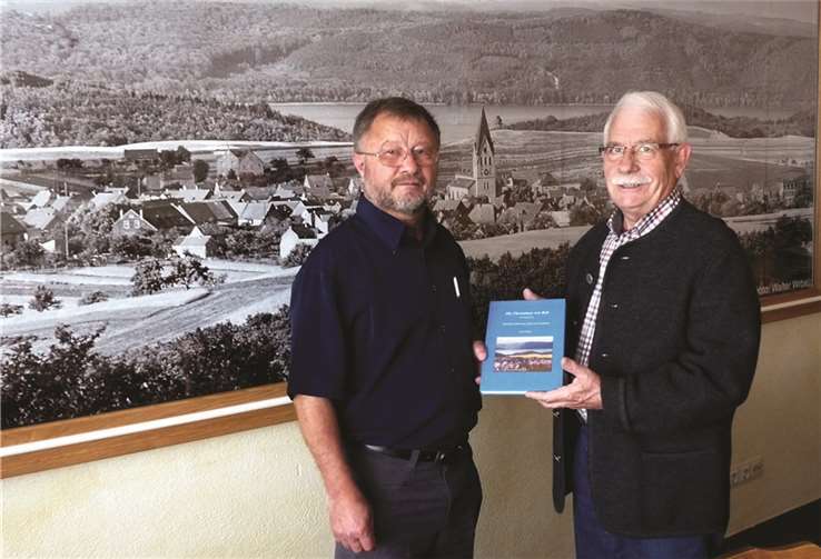In alter Verbundenheit zu seiner Heimatgemeinde Bell überreicht der Autor Horst Schlich (r.)  Ortsbürgermeister Bernd Merkler ein Exemplar seines Erstlingswerkes. SF 