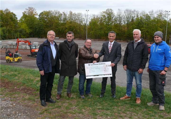 In der Bildmitte überreicht Stefan Hackenbruch den Scheck an den TUS-Vorstandsvorsitzenden Jürgen Frensch, inmitten der Baustelle. .privat