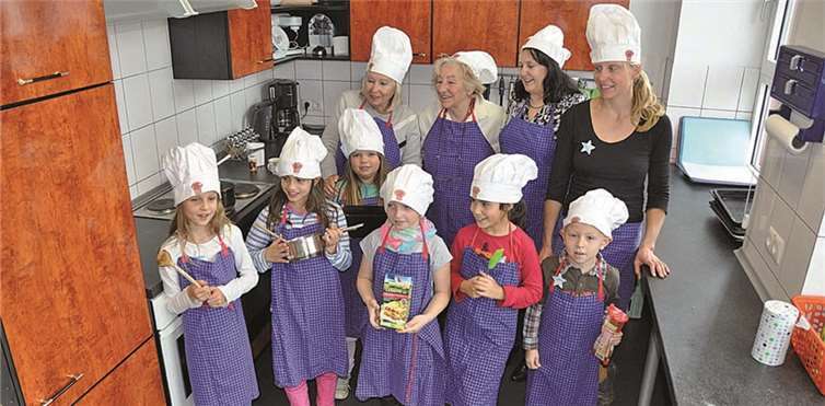 In der Küche der Grundschule werden gemeinsam internationale Gerichte von kleinen und großen Köchen zubereitet. -AB-