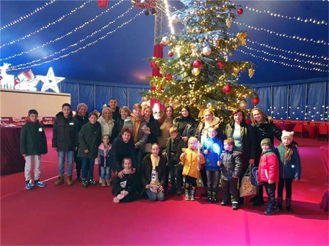 In der Pause stellte sich ein Teil der ukrainischen Gäste vor den festlich geschmückten Weihnachtsbaum, der sich im Foyer des Zirkusses befand, während andere die Gelegenheit wahrnahmen, eine Runde mit den Zirkuspferden durch die Manege zu reiten. Foto: privat