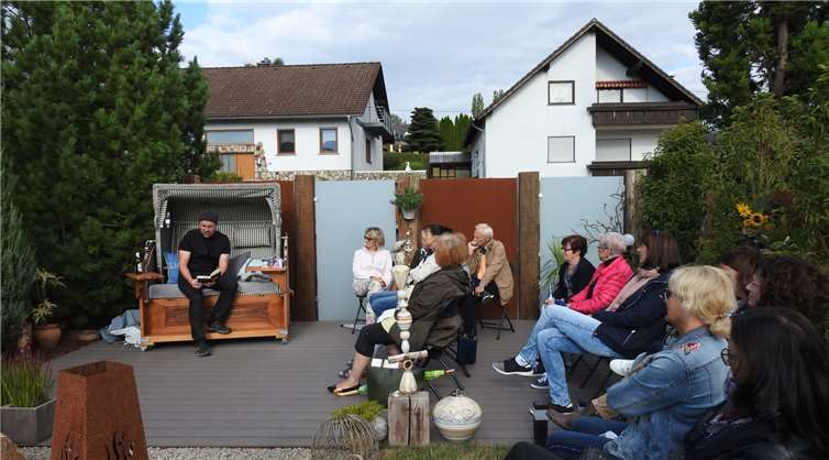 In drei Großmaischeider Gärten, hier Anke und Peters Gartenidylle, lasen Bürger aus dem Ort Passagen aus ihren Lieblingsbüchern. Thomas Böhm hatte sich im Outfit von Torsten Sträter dessen Werk „Selbstbeherrschung umständehalber abzugeben“ ausgesucht. Fotos: -KER-