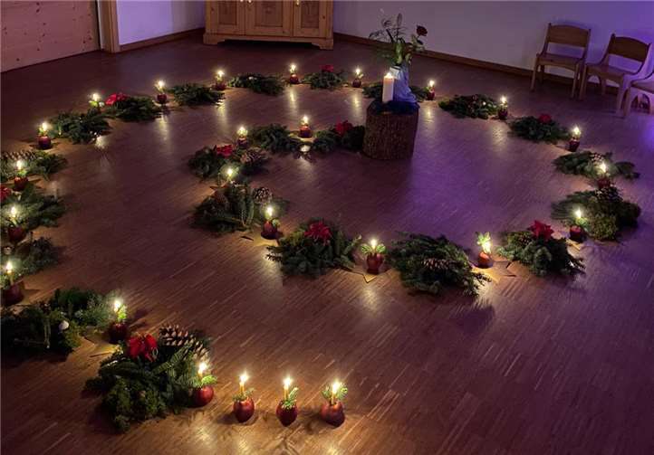 In einem abgedunkelten Raum wird Tannenreisig spiralförmig auf dem Boden dekoriert.Foto: privat