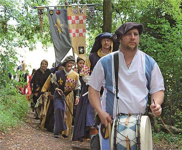 In einem langen Zug schreiten die Ritter und ihr Gefolge auf den Platz der Amtshandlung.