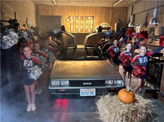 Cheerleader begeisterten mit gelungener Performance In ihren tollen Uniformen begeisterten die Mädels das Publikum mit einer gelungenen Performance und posierten im Anschluss neben dem Highlight der Autoausstellung, einem DeLorean, bekannt aus der Filmreihe „Zurück in die Zukunft“. Foto: privat
