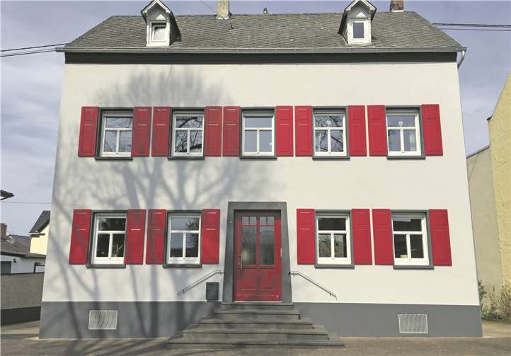 In neuem Glanz: Das Haus erhielt eine stilgerechte Aufwertung der Fassade durch den Einbau gegliederter Holzfenster mit Klappläden, einer neuen Haustür und durch die Überarbeitung der Fassade und des Fassadenanstrichs.