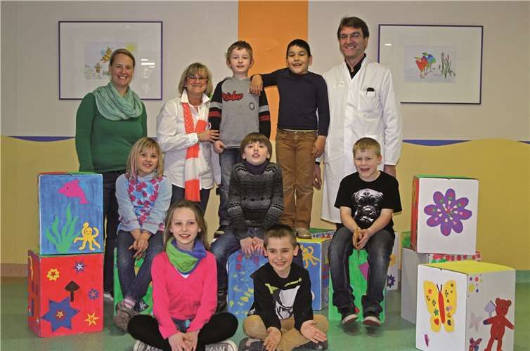 Ina Koch, Lehrerin, Ulrike Börder-Sauerbrei, Vorstandsmitglied des Fördervereins und Dr. Urban Himbert, Chefarzt der Klinik für Kinder- und Jugendmedizin mit einigen Schülern bei der Spendenübergabe.privat