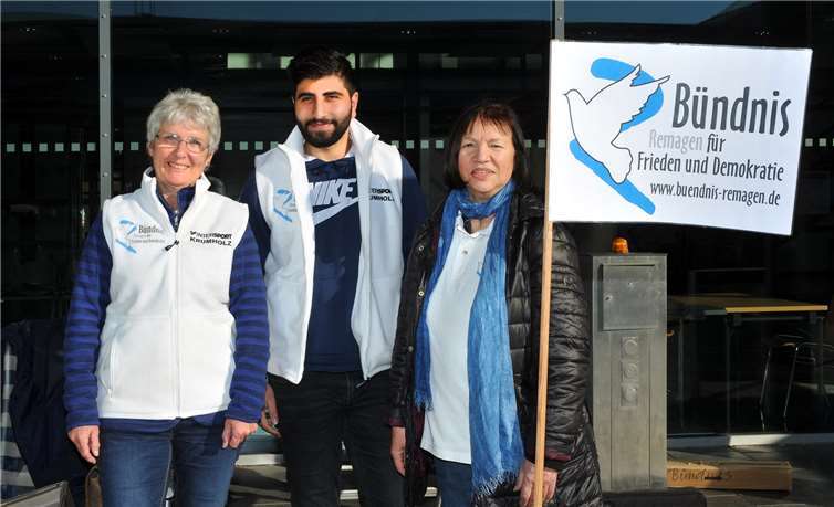 Infostand des Bündnisses „Remagen für Frieden und Demokratie“ (von links): Karin Keelan (Sprechergruppe des Friedensbündnisses und Hauptorganisatorin für das Bündnis am Tag der Demokratie), Hasan Sidou (junger Kurde aus Afrin, der sich für das Bündnis engagiert) und Rita Kupfer (Sprechergruppe).RASCH
