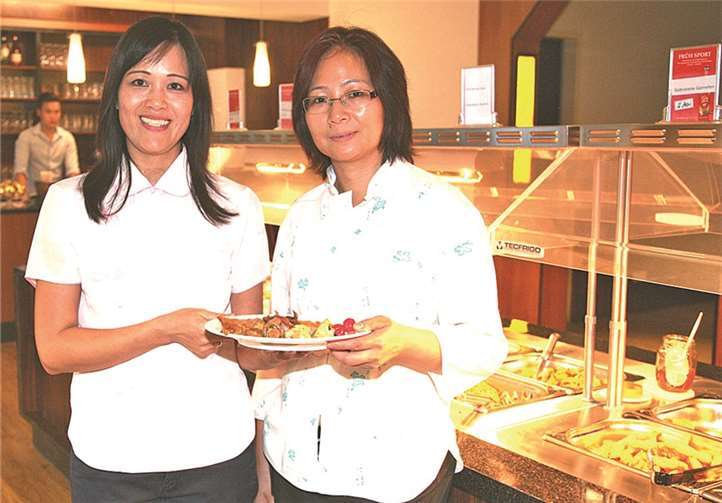 Inhaberin Mei Chen erklärt die zahlreichen Speisen aus dem vielfältigen Buffet. StF