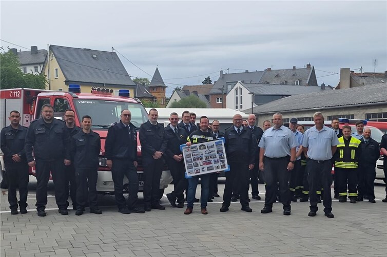 Inmitten der Floriansjünger aus der Verbandsgemeinde Vordereifel freut sich Bürgermeister Timo Kanzinger (Mitte, mit Fotorahmen) über die gelungene Überraschung beim Antrittsbesuch der Freiwilligen Feuerwehren zu seinem Amtsbeginn.