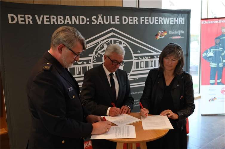 Innenminister Roger Lewentz, Klaudia Engels - stellv. Geschäftsführerin Unfallkasse Rheinland-Pfalz und Frank Hachemer - Präsident des Landesfeuerwehrverbandes Rheinland-Pfalz unterschreiben die Erklärung. Quelle: Landesfeuerwehrverband Rheinland-Pfalz