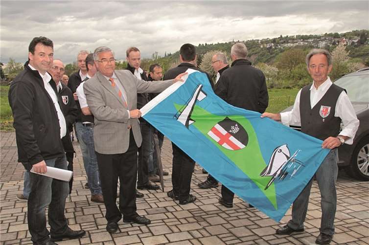 Inselbürgermeister Josef Gans (2. von links) übergab dem Vorsitzenden der Kirmesgesellschaft Peter Strohof eine neue Ortsfahne.