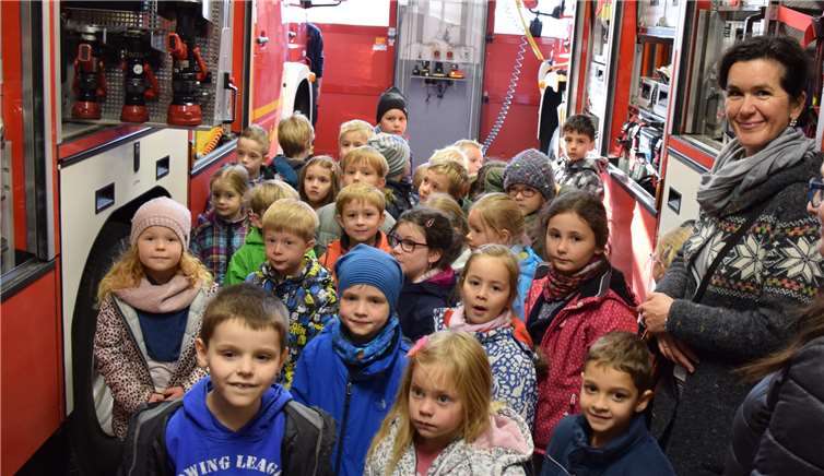 Interessiert lauschen die Kinder aus der Kath. Grundschule Sankt Martin und dem Kath. Kindergarten Liebfrauenwiese beim Projekttag „Feuer“ in der Feuerwache Rheinbach. Feuerwehr Rheinbach.