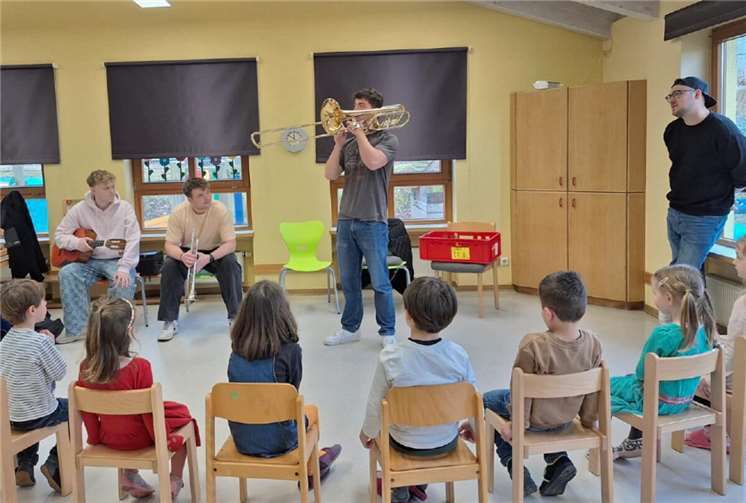 Interessiert lauschten die Kita-Kindern den drei Abiturienten Jakob (Gitarre), Paul (Trompete) und Roman (Posaune) vom Landesmusikgymnasium Rheinland-Pfalz aus Montabaur, die den kleinen Zuhörerinnen und Zuhörern die Welt der Klänge näherbrachten.  Foto: Kita Löwenzahn/Judith Böcker