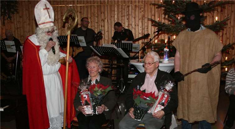Irene Weiland (88 Jahre) und Hermann Nachtsheim (93 Jahre)erhielten als älteste Anwesende von St. Nikolausein „Lebenselixier“ und einen Weihnachtsstern.