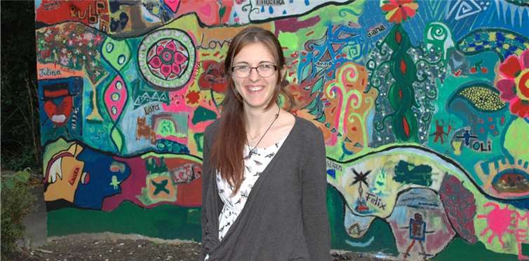 Irina Buruiana arbeitete für drei Wochen im HoT. Das Foto entstand vor der von ihr und den HoT-Besuchern während des Sommerferiensprogramms neu und bunt gestalteten Garagenwand. BL