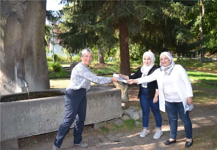 Irmgard Hillesheim (li.) überreicht Joud Damlakhi und Hoda Zidan das Grundgesetz. Foto: E.T. Müller