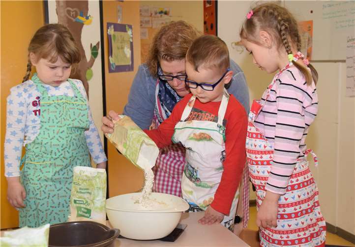 JONest-Leiterin Anja Ulrich mit Kindern beim Abwiegen der Zutaten. Foto: privat