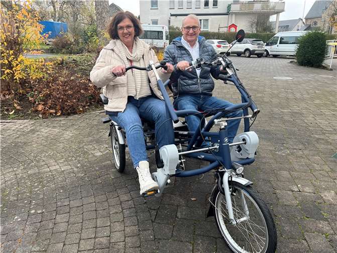 Ja, mir san mit’m Radl da: Walter Hartlich (re.), Vorsitzender des Stiftungsbeirates der Caritas-Stiftung Westerwald-Rhein-Lahn, übergab das E-Bike-Tandem Fun2Go an Andrea Berger, Abteilungsleiterin Behindertenhilfe „Wohnen, Assistenz und Bildung“ beim Caritasverband Westerwald-Rhein-Lahn. Das Rad im Wert von fast 12.000 Euro wurde speziell für Menschen mit Einschränkungen entwickelt und wird künftig von den Bewohnerinnen und Bewohnern des Caritas-Wohnheims St. Marien in Höhr-Grenzhausen genutzt. Die erste Runde im Hof der Einrichtung drehten Hartlich und Berger selbst. Quelle: Caritasverband Westerwald-Rhein-Lahn e. V.