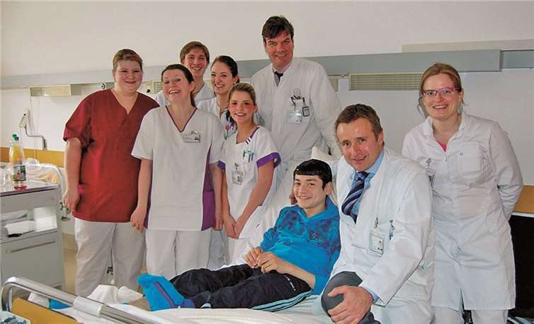 Jahongir strahlt. Viel Hilfe und Zuwendung erhält er im Stiftungsklinikum. Die Ärzte Dr. Erol Gercek (sitzend) und Dr. Philipp Drees (stehend dahinter) fördern das besondere Kinderhilfsprojekt.  Privat