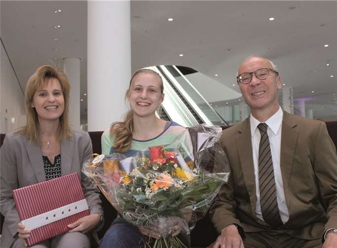 Janine Jacobs (Mitte) wurde von Kulturdezernent Detlef Knopp und Bibliotheksdirektorin Susanne Ott mit Blumenstrauß und Buchpräsent „überrascht“. privat