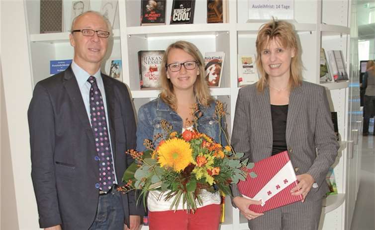 Jennifer Richter (Mitte) ist die 100.000ste Besucherin der StadtBibliothek im Forum Confluentes. Kulturdezernent Detlef Knopp und Bibliotheksdirektorin Susanne Ott gratulierten und überreichten Blumen und ein Buchgeschenk.  Privat