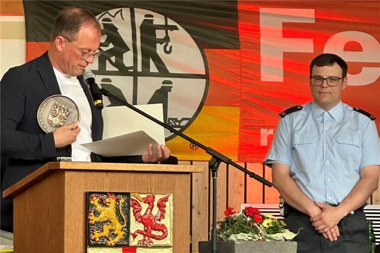 Jörg Lempertz, Bürgermeister VG Mendig, verlieh Benjamin Klapperich (rechts) für dessen Verdienste als Atemschutzgerätewart der Verbandsgemeinde den Kleinen Wappenteller der VG Mendig. 