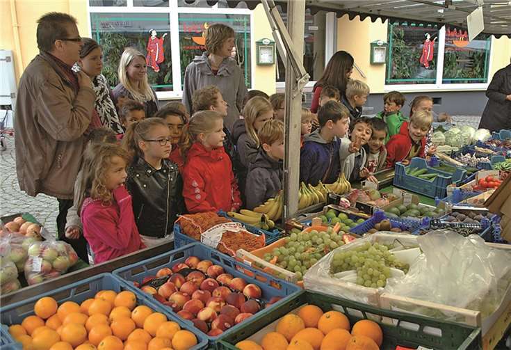 Johannes Büchel (r.) und die kleinen Marktforscher beim Besuch am Obststand. BL
