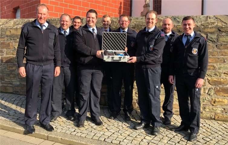 Johannes Selzer (4. v. l.) übergibt Michael Frings (3. v. r.) im Namen des anwesenden Vorstandes und der Wehrführung den Notrufkoffer.Foto: privat