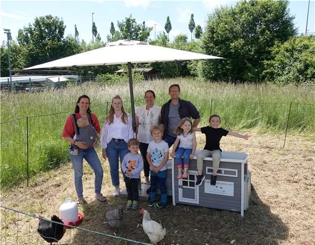Judith Nett (Elternausschuss), Katharina Natschke (Erzieherin), Carolin Strieth (Elternausschuss) und Stefan Ibs (Leiter) mit Kindern des Blandine-Merten-Hauses am Hühnerstall. Foto: Kath. Kita Blandine-Merten-Haus, Stefan Ibs