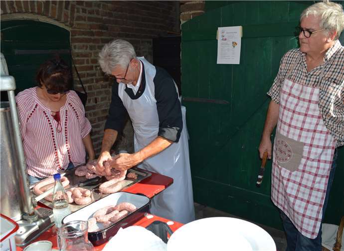Jürgen Walbröl füllt vor Publikum die Würste für den Grill.