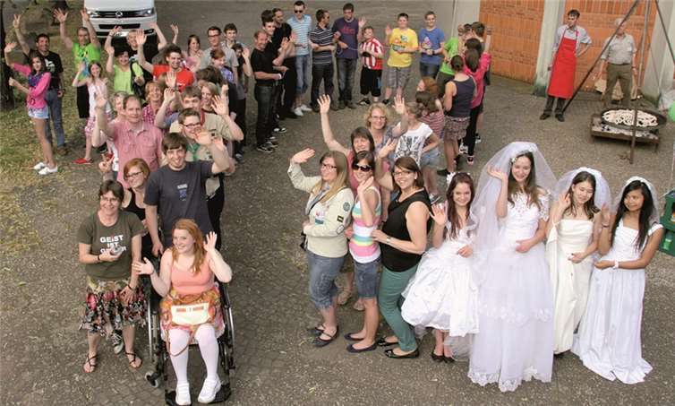 Jugendlichen haben sich zu einer symbolischen 72 aufgestellt: Die Mädchen vorne rechts tragen Brautkleider vom „2nd Hemd- und Hose-Markt“.Privat