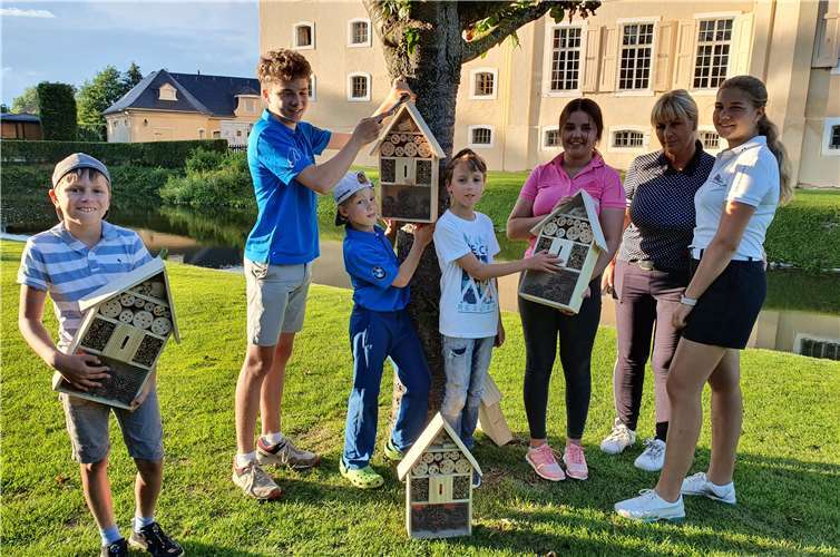 Jugendwartin Marion Meyer mit Golfer/innen beim Anbringen von Insektenhotels auf der Obstwiese. Foto: privat