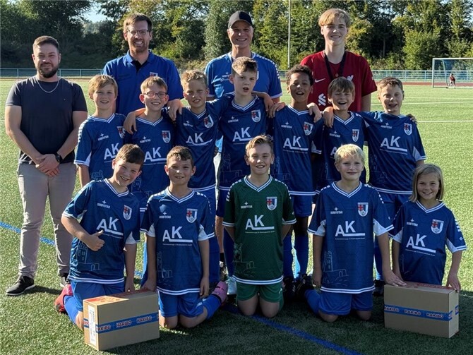 Julian Göderz, Betriebsleiter der AK Automatisierungs- und Elektrotechnik GmbH (li.) hat die neuen Trikots im Namen von Ralf Krämer und Ralf Rütze vor einem Heimspiel an die Spielerinnen und Spieler der E1 (Jahrgang 2015) um Cheftrainer Christoph Haupt (2. v. r.) und Co-Trainer Julian Rinke (r.) übergeben. Zur Freude der Jugendkicker und Vorsitzendem Sebastian Neises (2. v. l.)hatte Julian Göderz auch noch eine süße Überraschung im Gepäck. Bei den Trikots kommt ebenfalls das neue individuelle Design zum Einsatz und verhilft der SV-Jugend weiter zu einem einheitlichen Auftreten.  Foto: privat