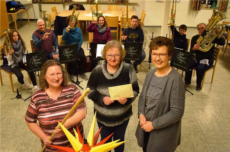 Jutta Treis und Inge Appel überreichten Posaunenchorleiterin Petra Wiegand (von links) die Spenden des Lebendigen Adventskalenders Nassau. Darüber freuten sich auch die Bläserinnen und Bläser des Chores. Foto: Dekanat Nassauer Land