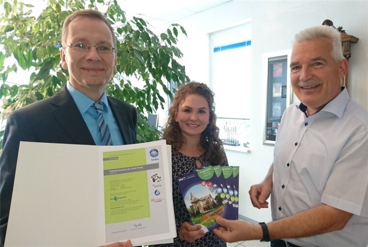 KRUPP DRUCK-Geschäftsführer Peter Krupp überreichte die Zertifikats-Urkunde an Bürgermeister Andreas Geron und VHS-Geschäftsführerin Sophie Kessel. KRUPP Pressebild