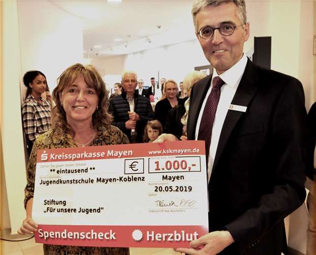 KSK-Vorstandsvorsitzender Karl-Josef Esch überreicht derDozentin Christina Weise einen Scheck in Höhe von 1000 Euro.