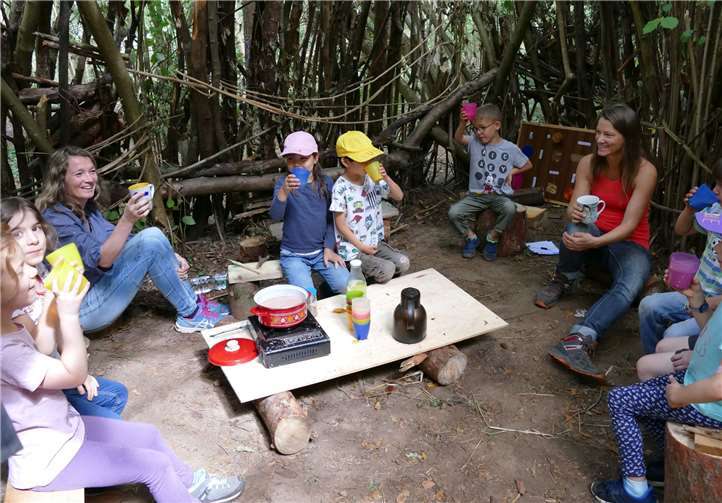 Kakaopause in der selbstgebauten Hütte: Die Kinder genießen das Gemeinschaftsgefühl.