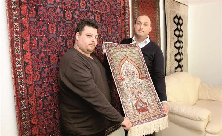 Kalli Dietsch (l.) präsentiert im ansprechenden Ladenlokal in Dernau einen wertvollen Seidenteppich. BÜN