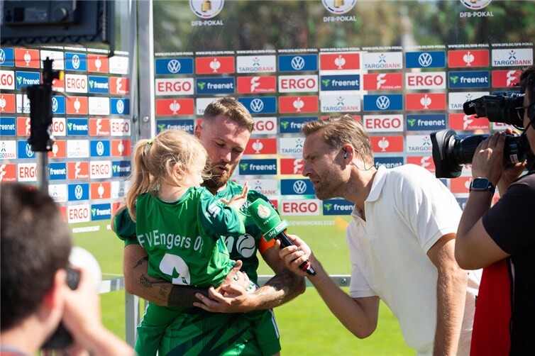 Kapitän Chris Meinert - hier mit seiner Tochter beim Sky-Interview - und des ganze FV Engers haben sich beim Pokalspiel gegen Eintracht Frankfurt als sympathischer und toll organisierter Club verkauft.