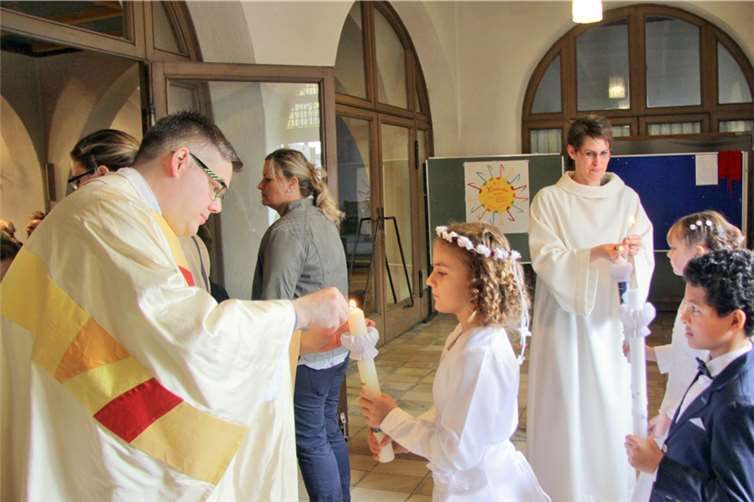 Kaplan Ulrich Eßer und Pastoralreferentin Andrea Titt entzündeten die Kommunionskerzen im Kirchenvorraum.
