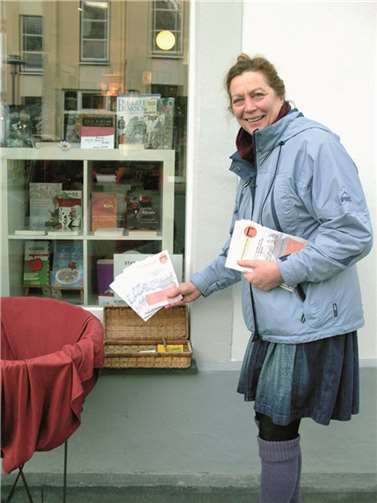 Karin Meiner legt ihre Flyer vor einem Buchgeschäft aus.